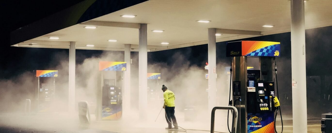 man in yellow jacket standing near gas pump