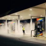 man in yellow jacket standing near gas pump