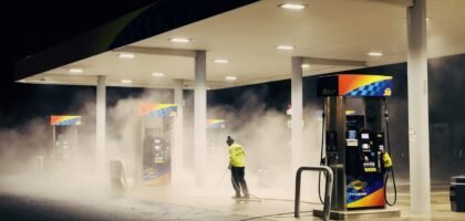 man in yellow jacket standing near gas pump