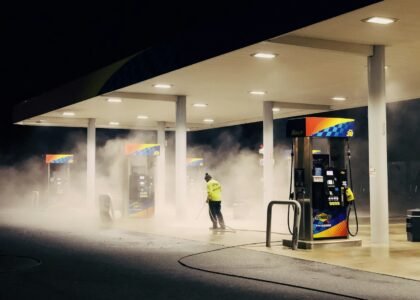 man in yellow jacket standing near gas pump
